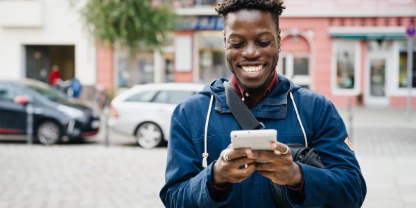 Man smiling while using smartphone.