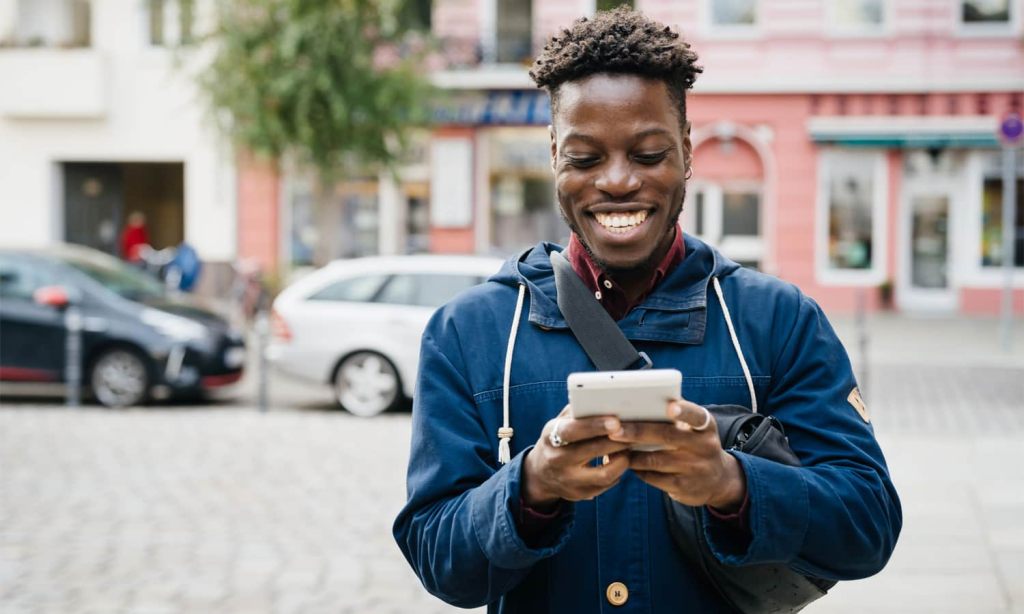 Man smiling while using smartphone.