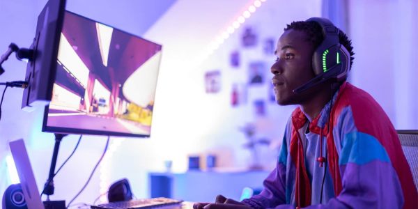 Young male gamer playing with a controller at night.