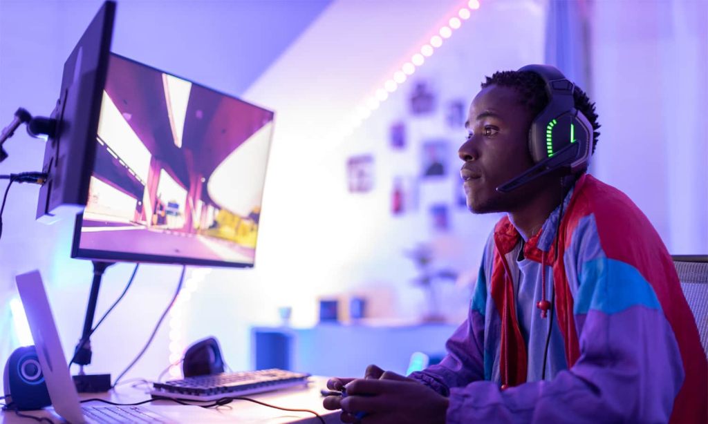 Young male gamer playing with a controller at night.