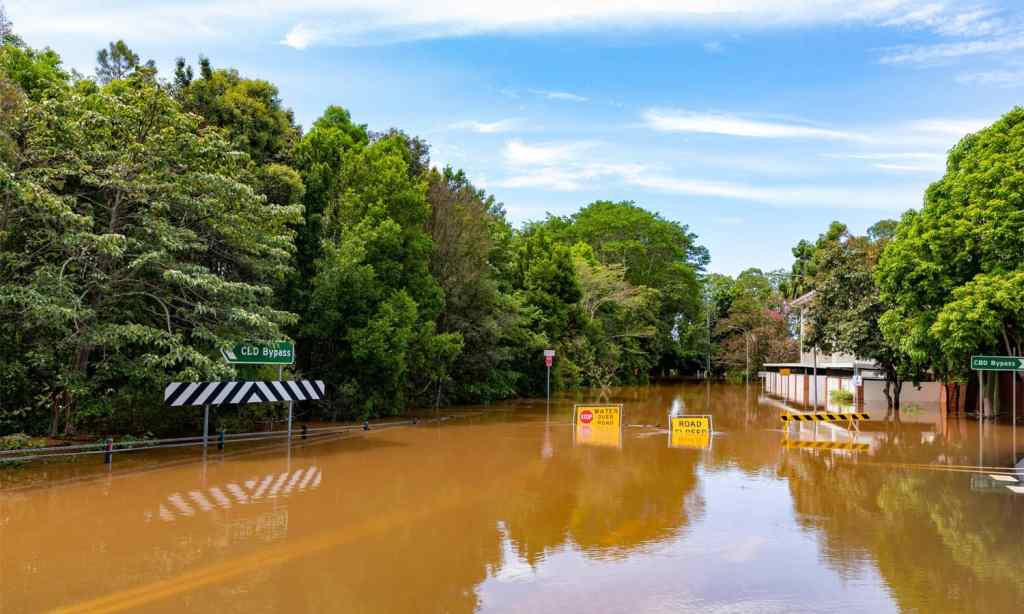 Flood sign on a road under water near the Lismore, NSW CBD.