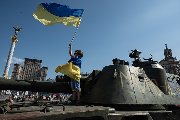 A boy waving Ukraine's Flag.