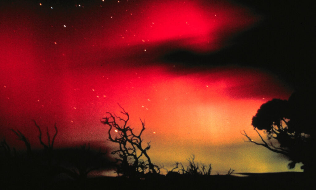An image of glowing red skies showcasing the southern lights in Tasmania.
