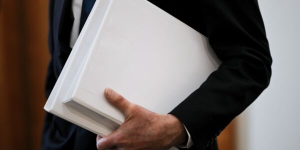 An image showing a politian holding a file to illustrate the secret ONI report that the Australian government will not release