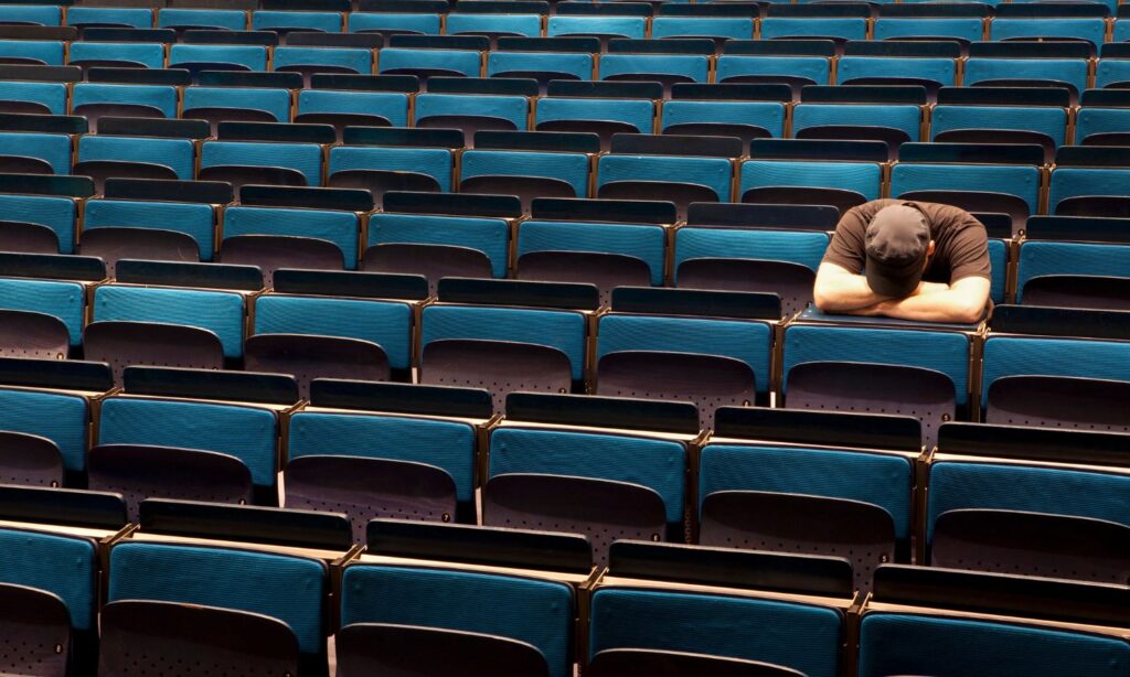 An image showing a sad person at university to illustrate an article on mental health and depression at university.