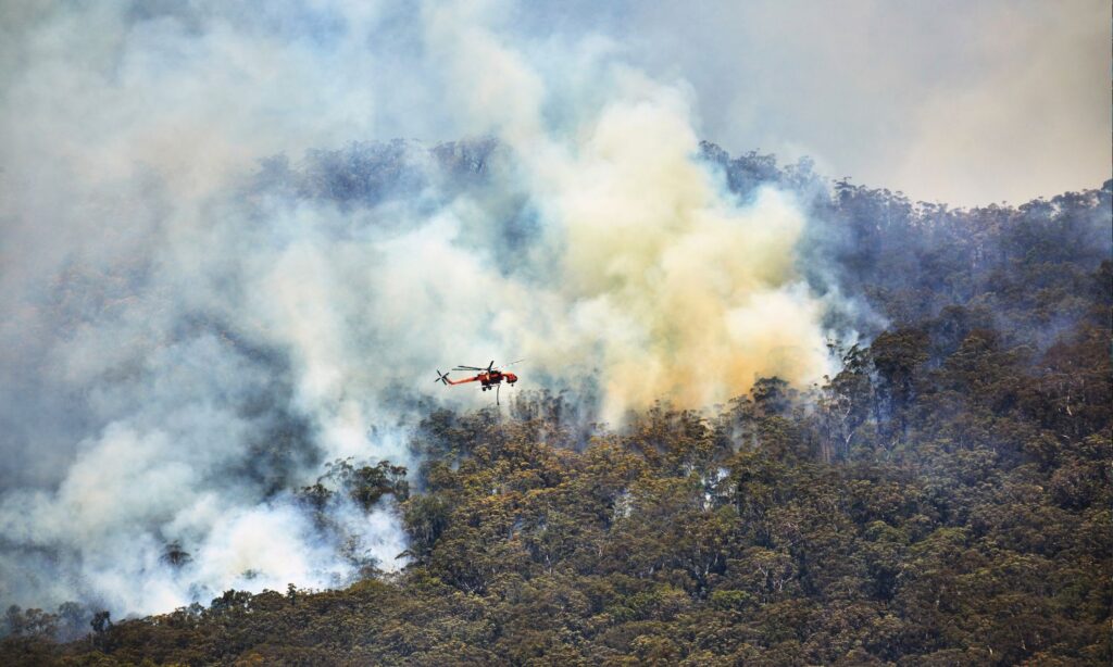 A photo of a helicopter fighting a bushfire in Australia, probably not using AI