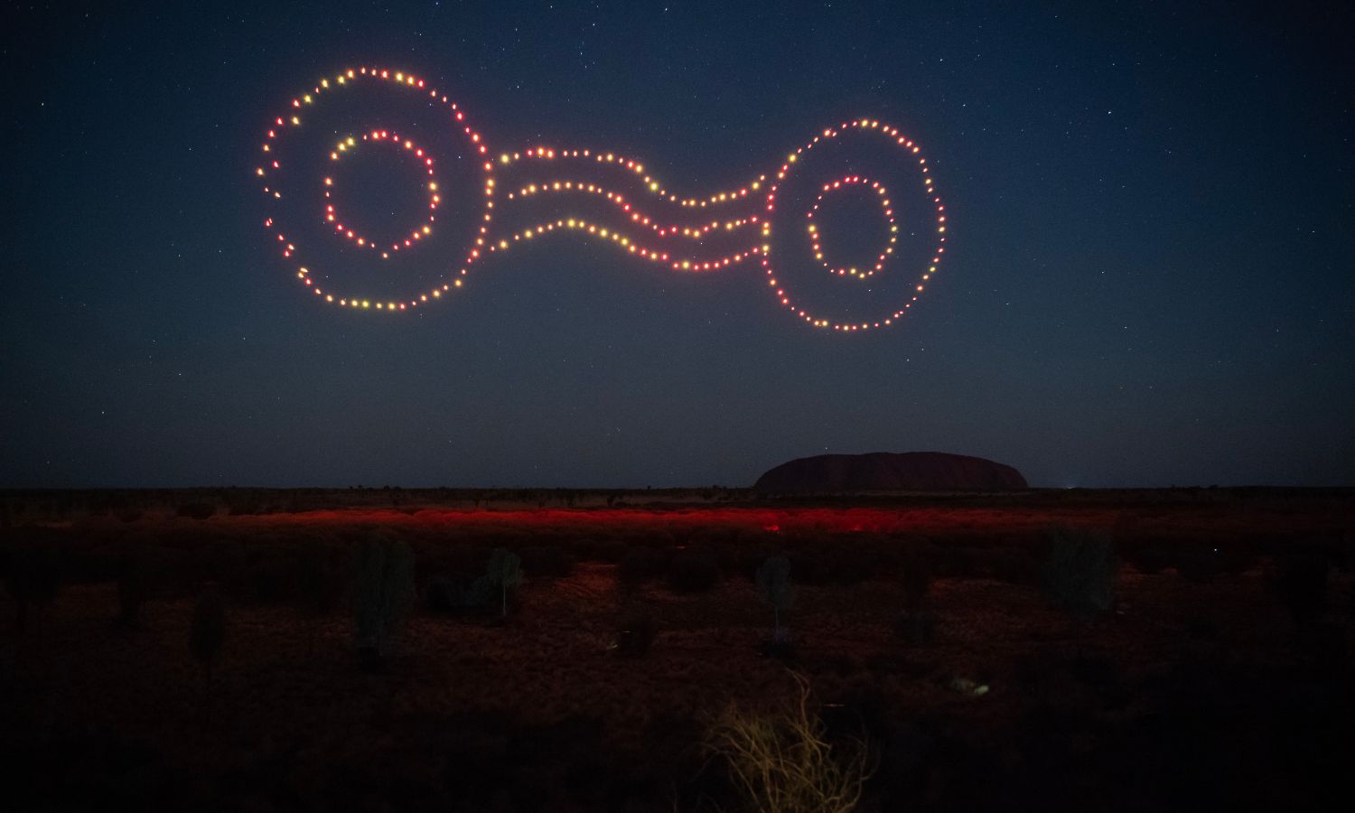 An image showing drone art above Uluru 